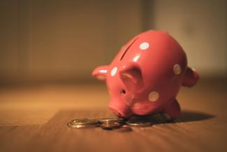 pink pig coin bank on brown wooden table by Andre Taissin courtesy of Unsplash.