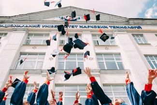 group of fresh graduates students throwing their academic hat in the air by Vasily Koloda courtesy of Unsplash.