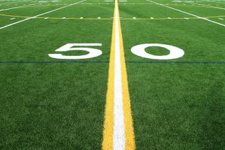 a football field with the number sixty on it by Mario Verduzco courtesy of Unsplash.