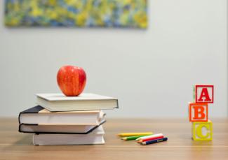 red apple fruit on four pyle books by Element5 Digital courtesy of Unsplash.