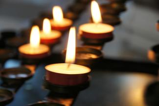 lighted candles on black metal candle holder by Eli Solitas courtesy of Unsplash.